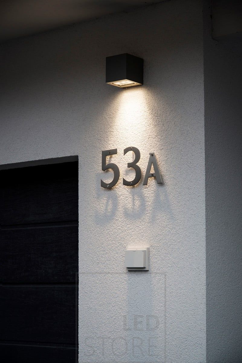 CUBIC OUT led wall light illuminating in one direction above the house number. The light is soft and warm at 3000 kelvin. Ledstore.fi